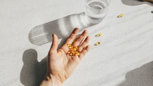 Eine Hand mit Vitamin D-Kapseln