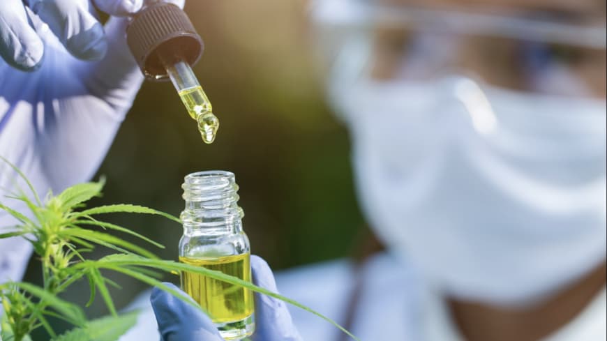 Wissenschaftlerporträt mit Maske, Brille und Handschuhen beim Forschen