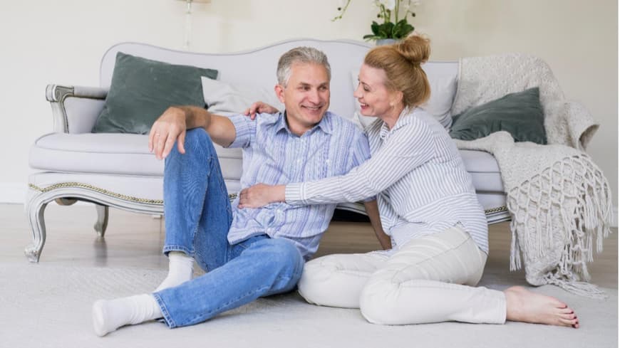 Ein Paar sitzt gemeinsam vor einer Couch