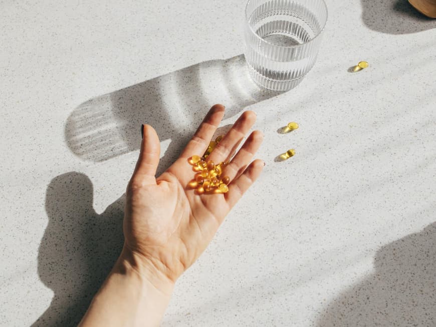 Eine Hand mit Vitamin D-Kapseln