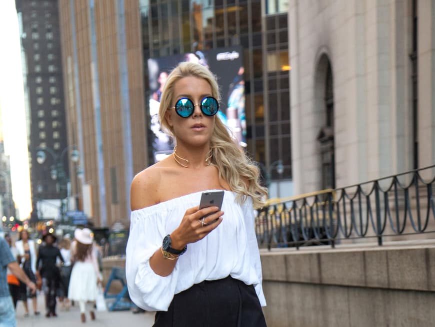 Lässig: Bloggerin Darcy Jones kombiniert zur weißen Carmen-Bluse schwarze Culottes und Ankle-Boots. 