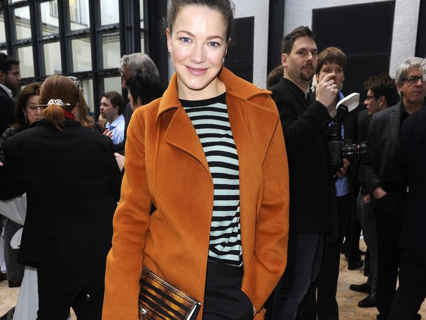 Fein gemacht: Schauspielerin Hannah Herzsprung kombiniert ihr Streifenshirt zu Zigarettenhose und rostfarbenem Mantel. 