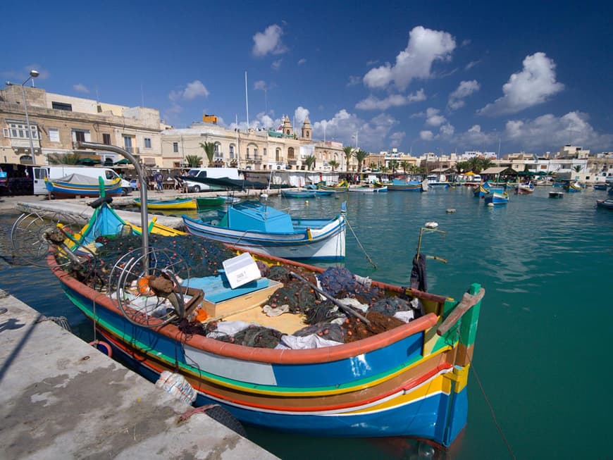 Das Fischerdorf Marsaxlokk glänzt mit einem stimmungsvollen Hafen, in dem bunte Boote ankern.