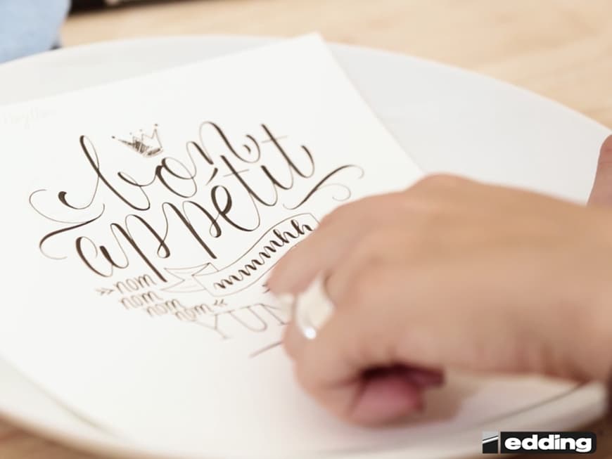 Den gewünschten Schriftzug entwirft Hannah zunächst probeweise auf dem Papier.