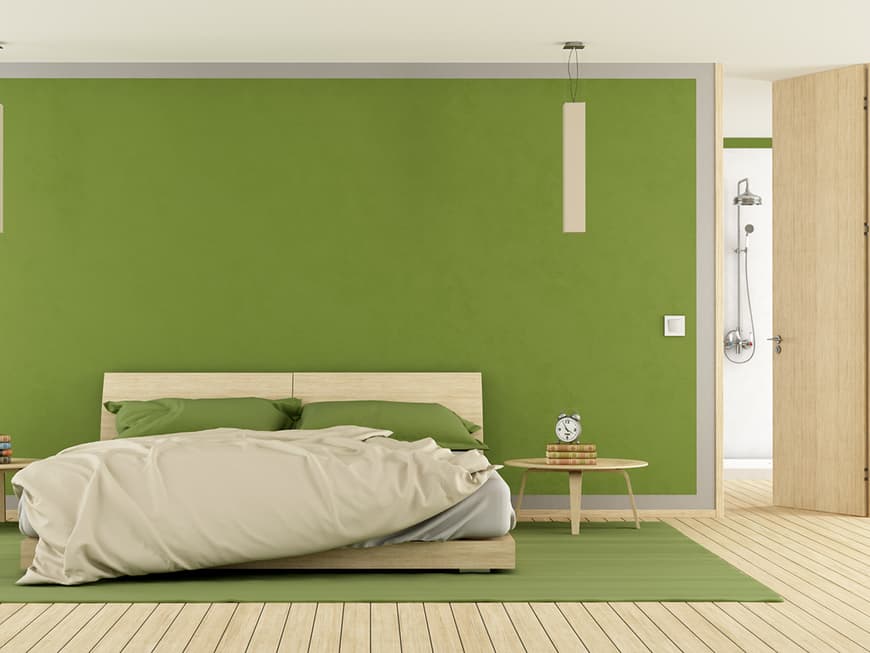 Auch im Schlafzimmer ist das frische Gelbgrün ein echter Hingucker und findet sich in weiteren Deko-Elementen wie Kissen und Teppich wieder.