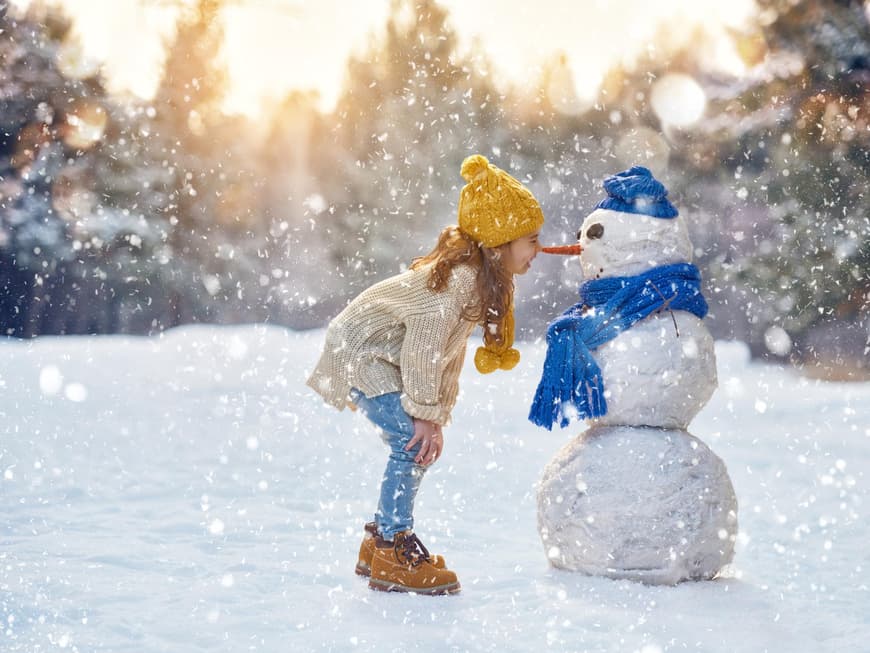 Kleines Mädchen mit Schneemann