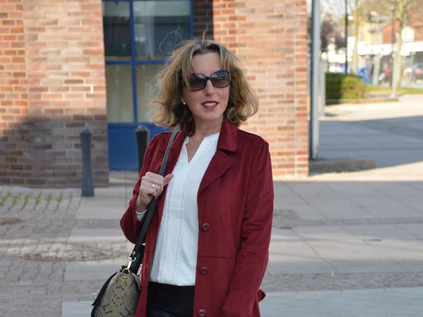 Wow-Look: Sportlich-elegant wird's mit der Kombi aus Lederimitathose zu Sneakern und weißer Bluse. Echter Hingucker: der rote Trench.