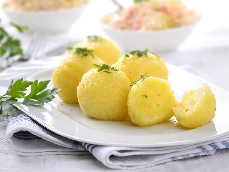 Kartoffelklöße mit Petersilie garniert auf einer Servierplatte