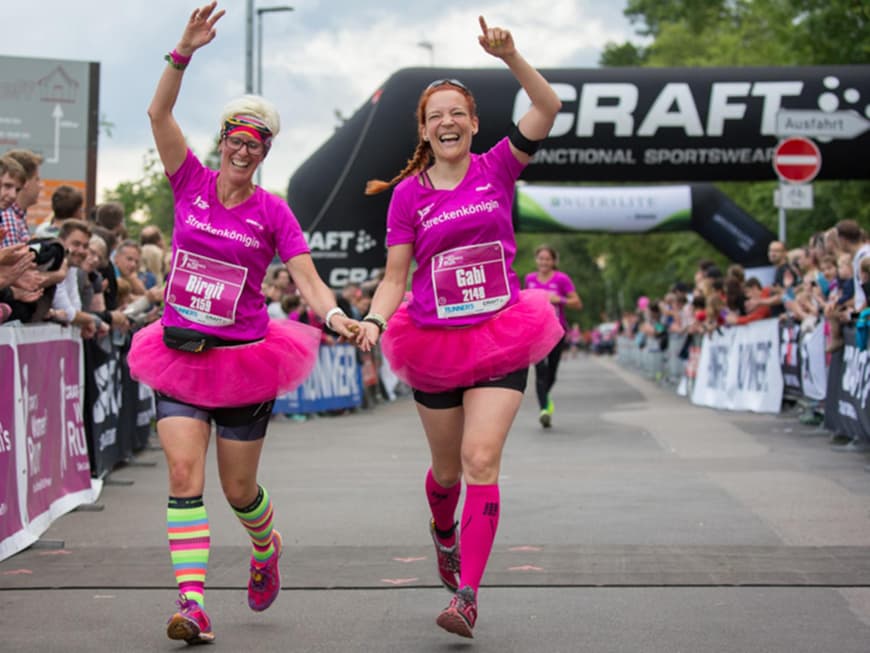 Zwei Frauen laufen kostümiert den Women's Run