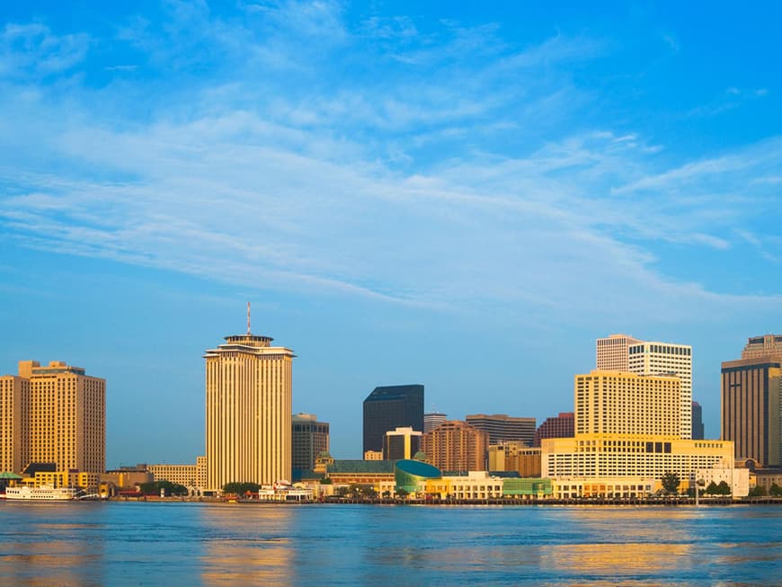 Blick vom Wasser aus auf die vom Sonnenlicht geküsste Skyline von New Orleans