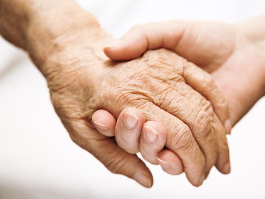 Eine junge Hand hält eine alte fest