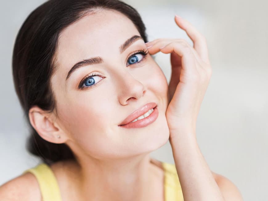 Brünette Frau mit blauen Augen und kupferfarbenem Lidschatten