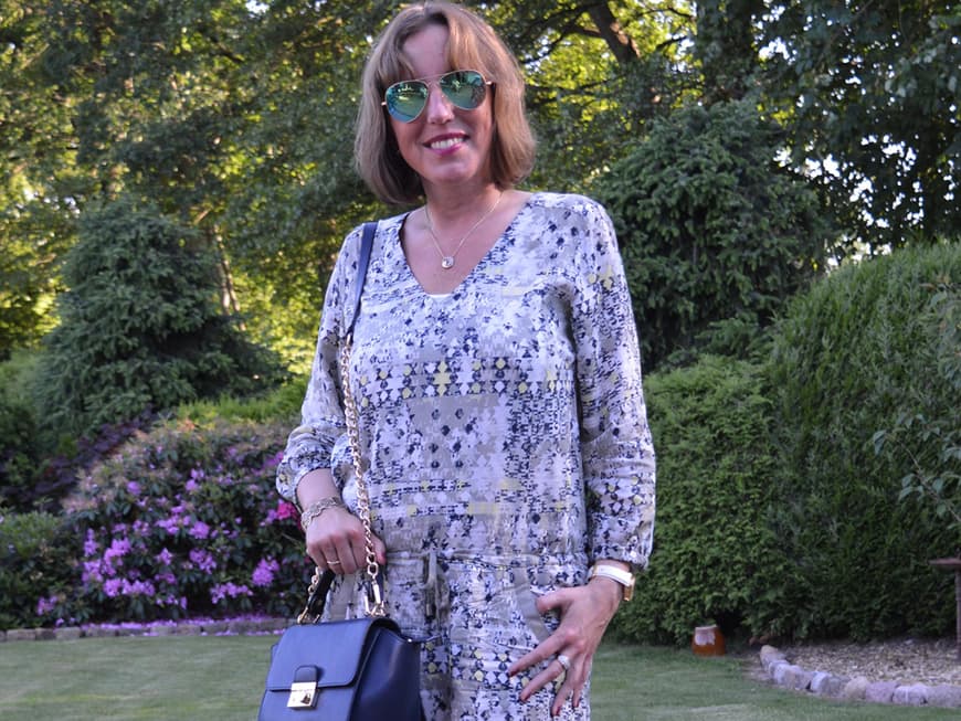Attraktive Frau mittleren Alters in gemustertem Sommerkleid