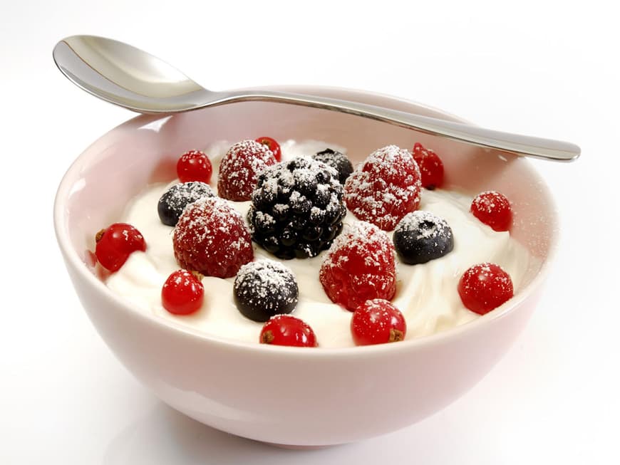 Schüssel mit Jogurt und Beeren und ein Löffel