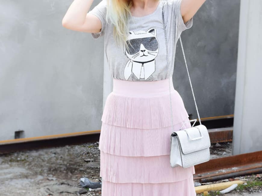 Chrissie mit grauem Karl Lagerfeld-T-Shirt zum zart rosafarbenen Rock mit Volants und weißen Pumps