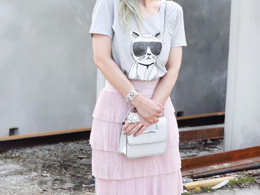 Chrissie mit grauem Karl Lagerfeld-T-Shirt zum zart rosafarbenen Rock mit Volants und weißen Pumps