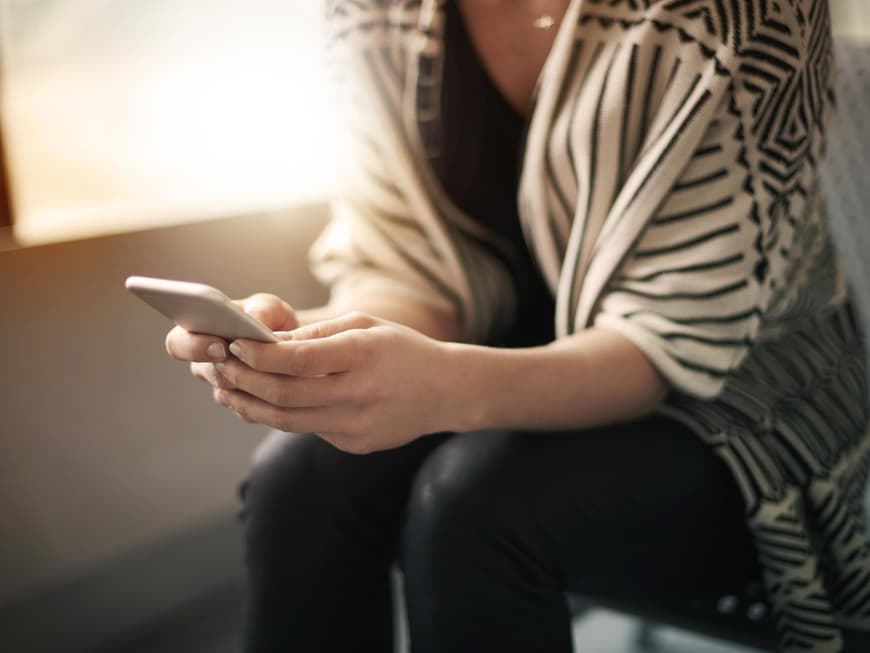 Frau hält ihr Smartphone in den Händen