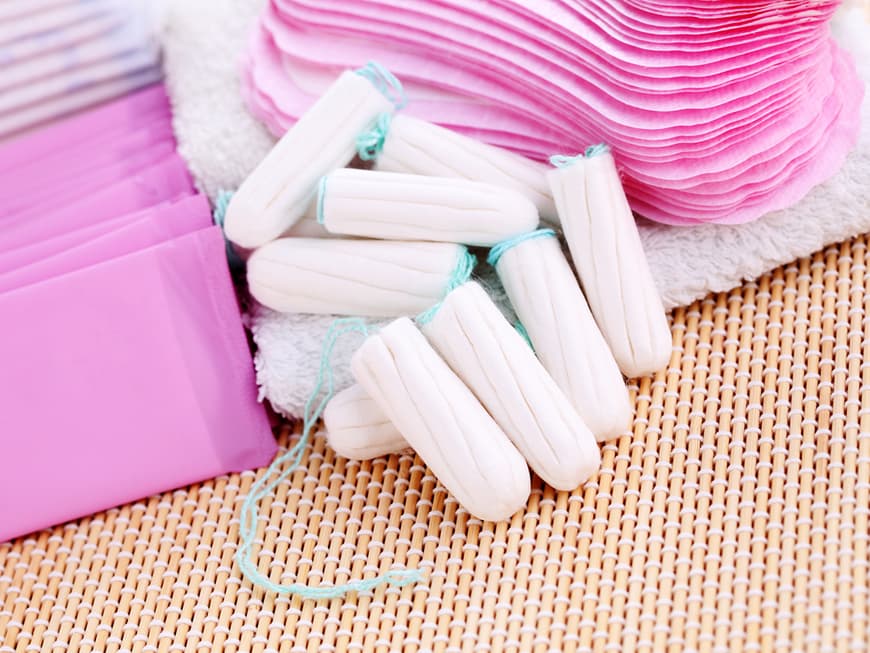 Mehrere Tampons neben verpackten Binden