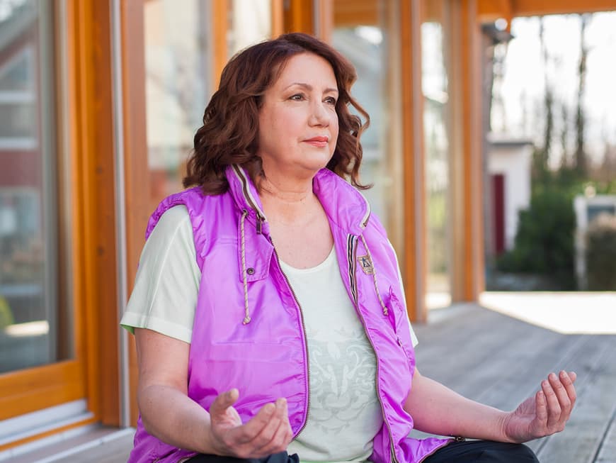 Frau im Lotussitz auf der Terrasse