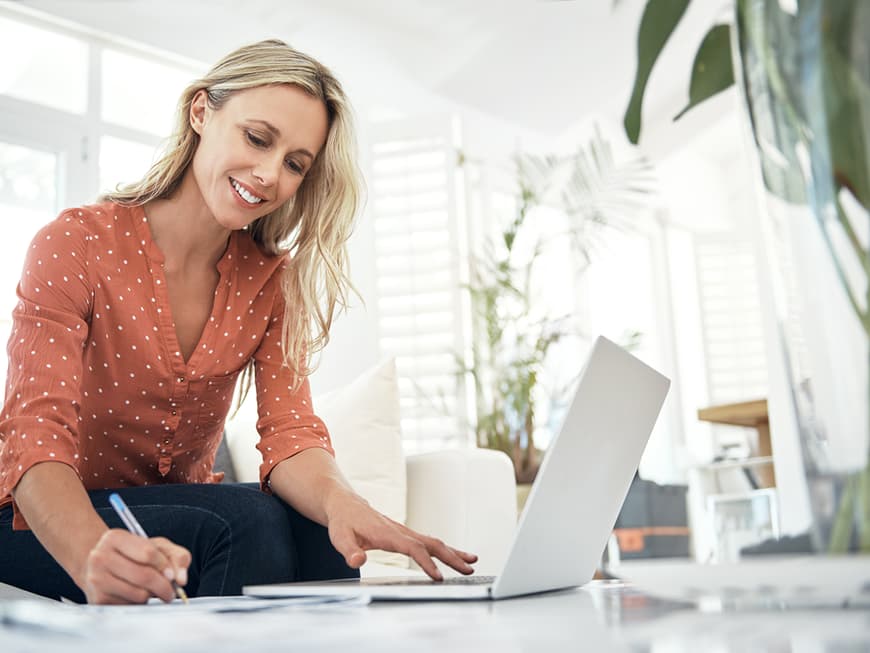 Blonde Frau sitzt vorm Laptop
