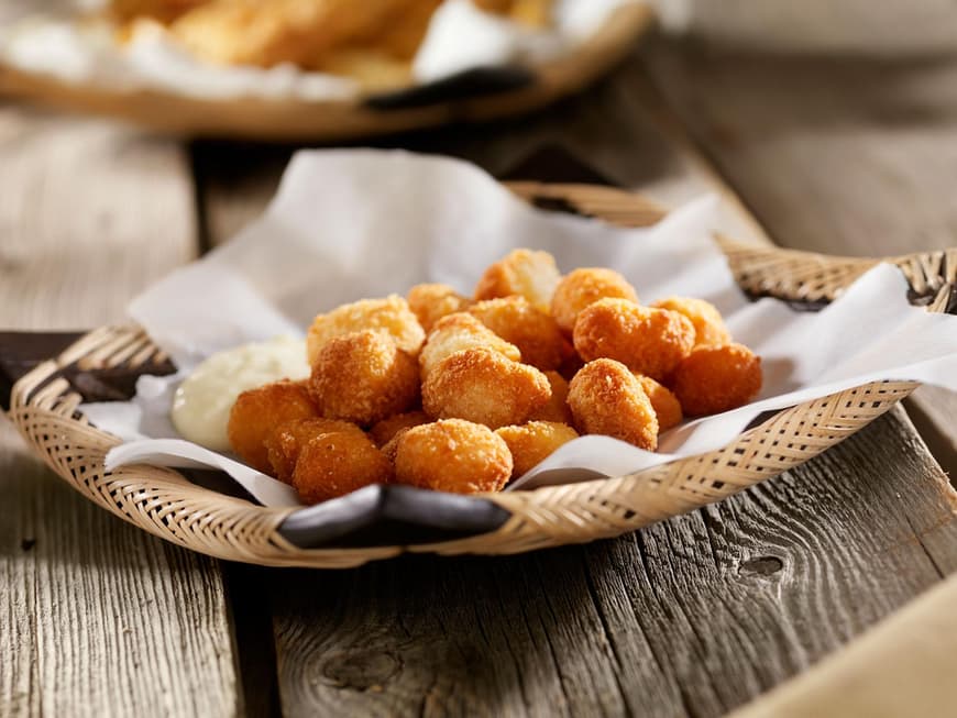 Teig ummantelte Bällchen in einer Schale auf Holztisch
