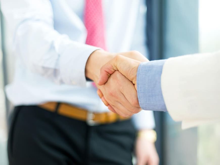 Zwei Business-Leute geben sich die Hand