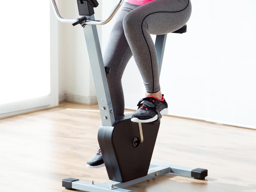 Junge Frau trainiert auf einem Spinning-Rad