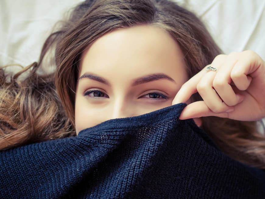 Frau versteckt sich in Pullover