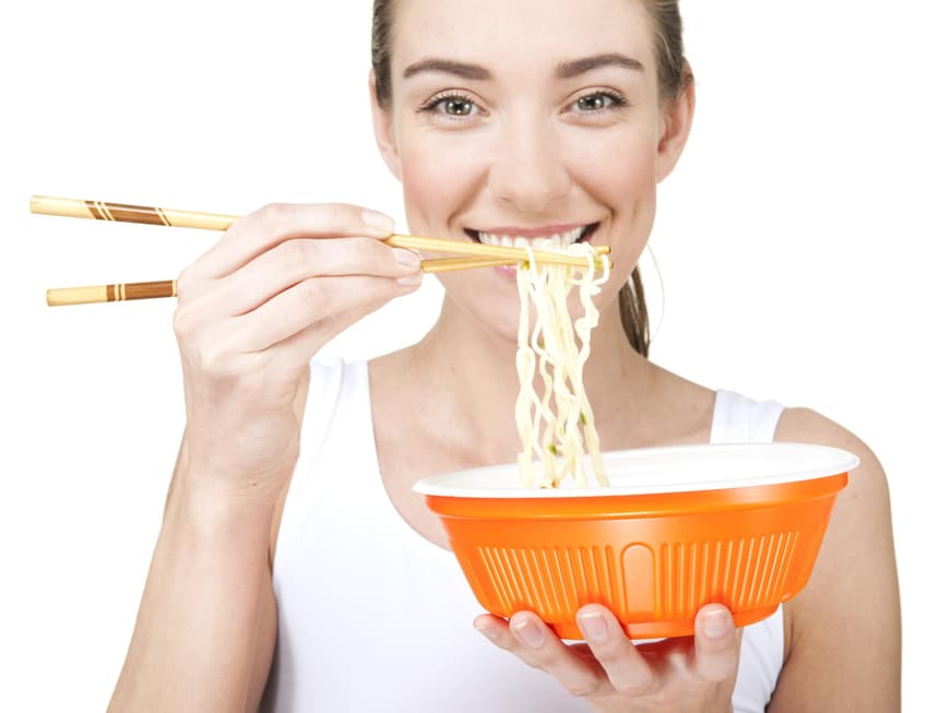 Frau isst Ramen mit Stäbchen