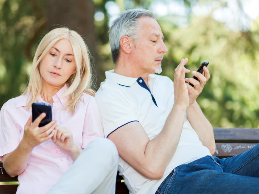 Mann und Frau blicken auf ihr Smartphone