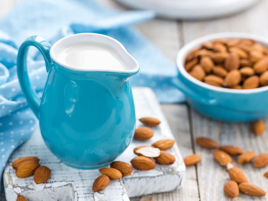 Kännchen mit Mandelmilch und Schüssel mit Mandeln