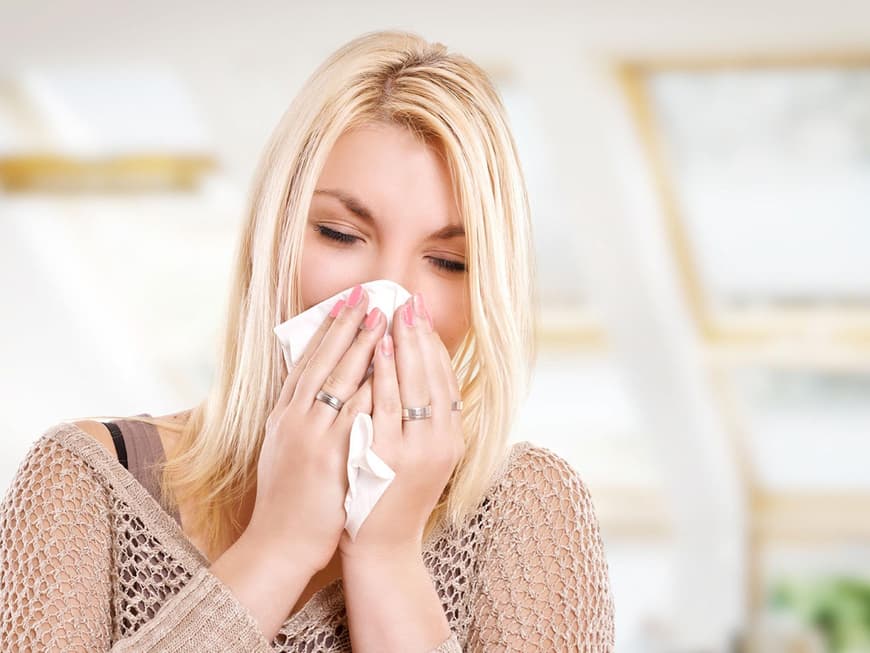 Frau mit Allergie putzt sich die Nase
