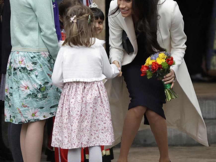 Megan Markle im weißen (Hochzeits)Mantel und weißen Barett