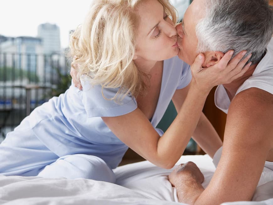 Älteres Paar küsst sich im Bett