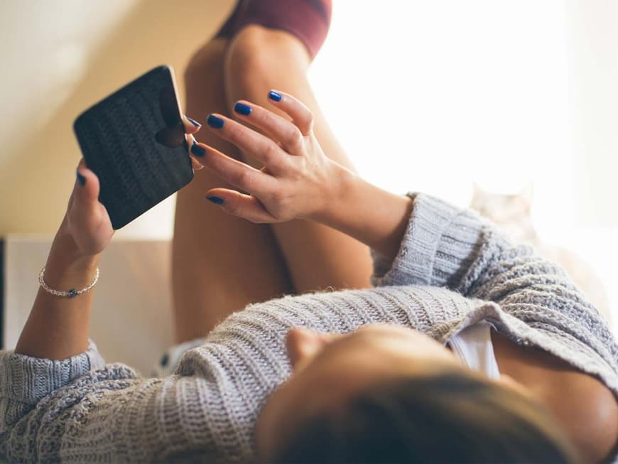 Sexting: Frau in erotischer Pose mit Handy