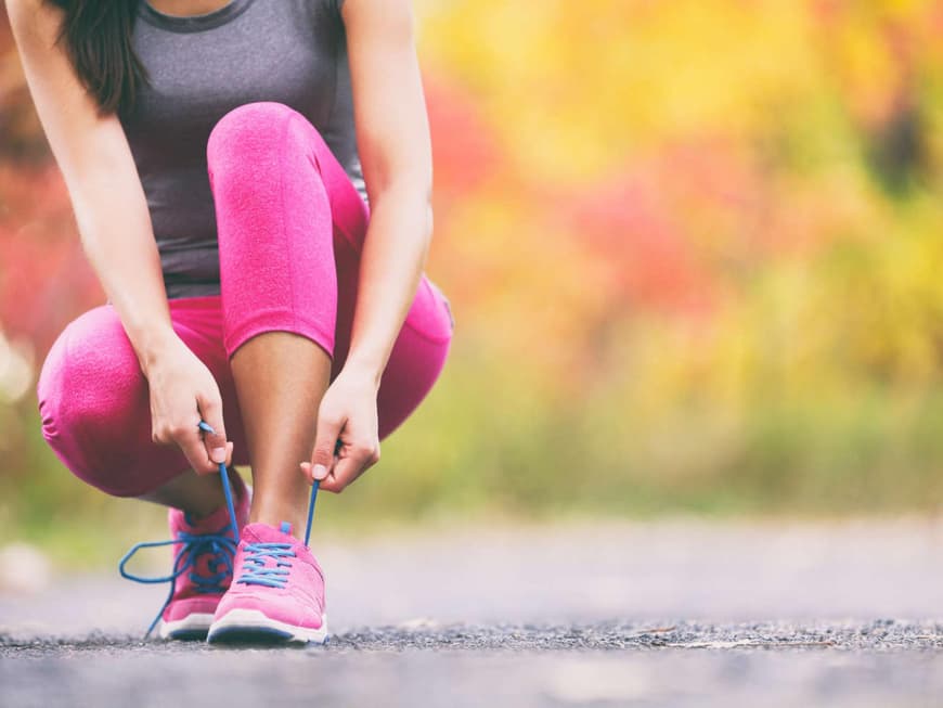 Joggerin schnürt sich die Schuhe zu